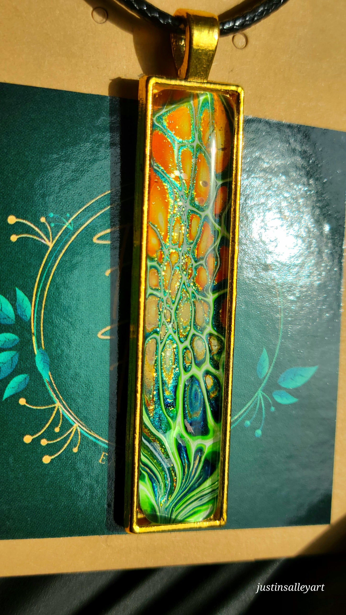 Handmade Fluid Art Gold Pendant on a black cord necklace with lobster clasp.