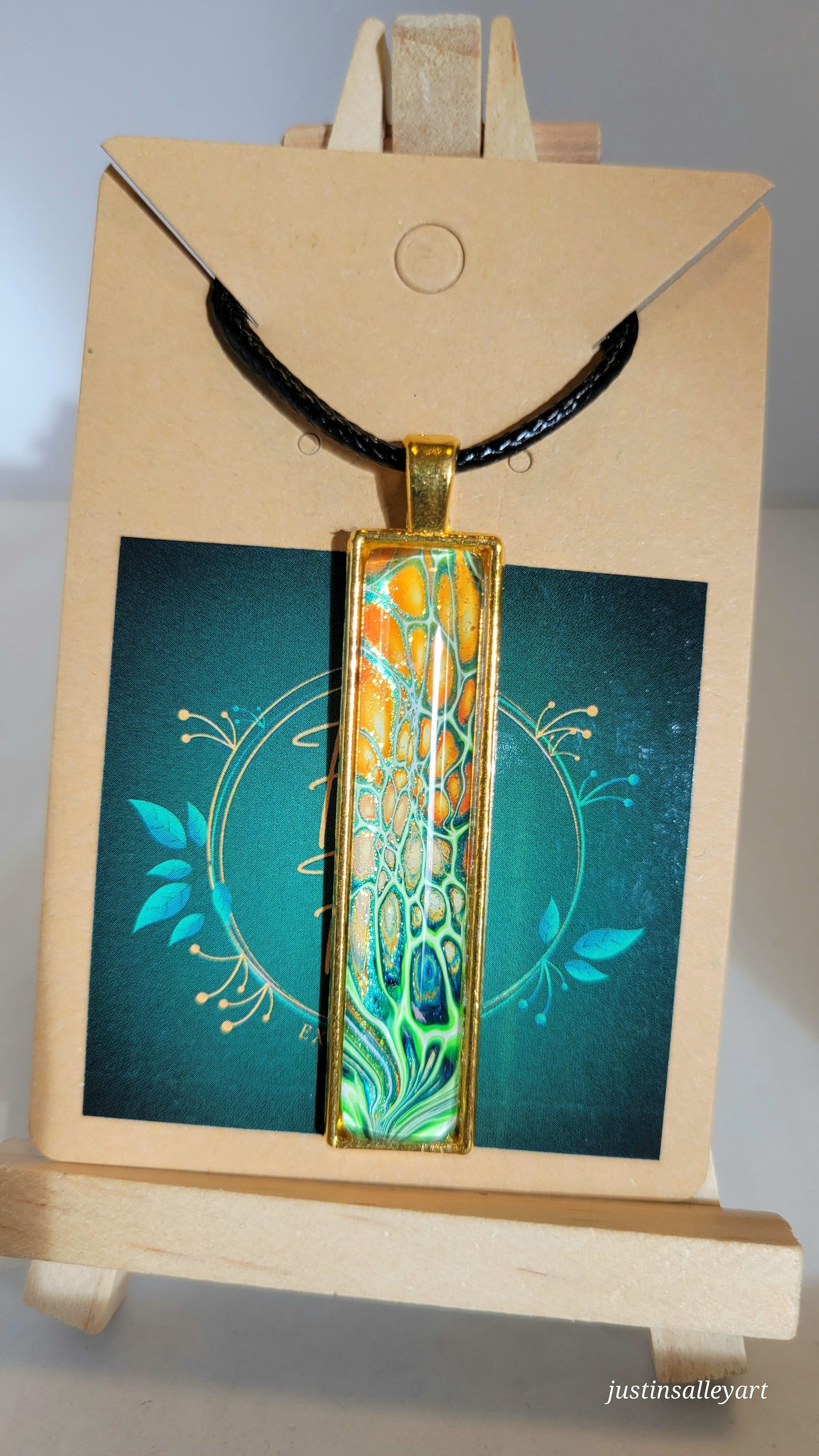 Handmade Fluid Art Gold Pendant on a black cord necklace with lobster clasp.
