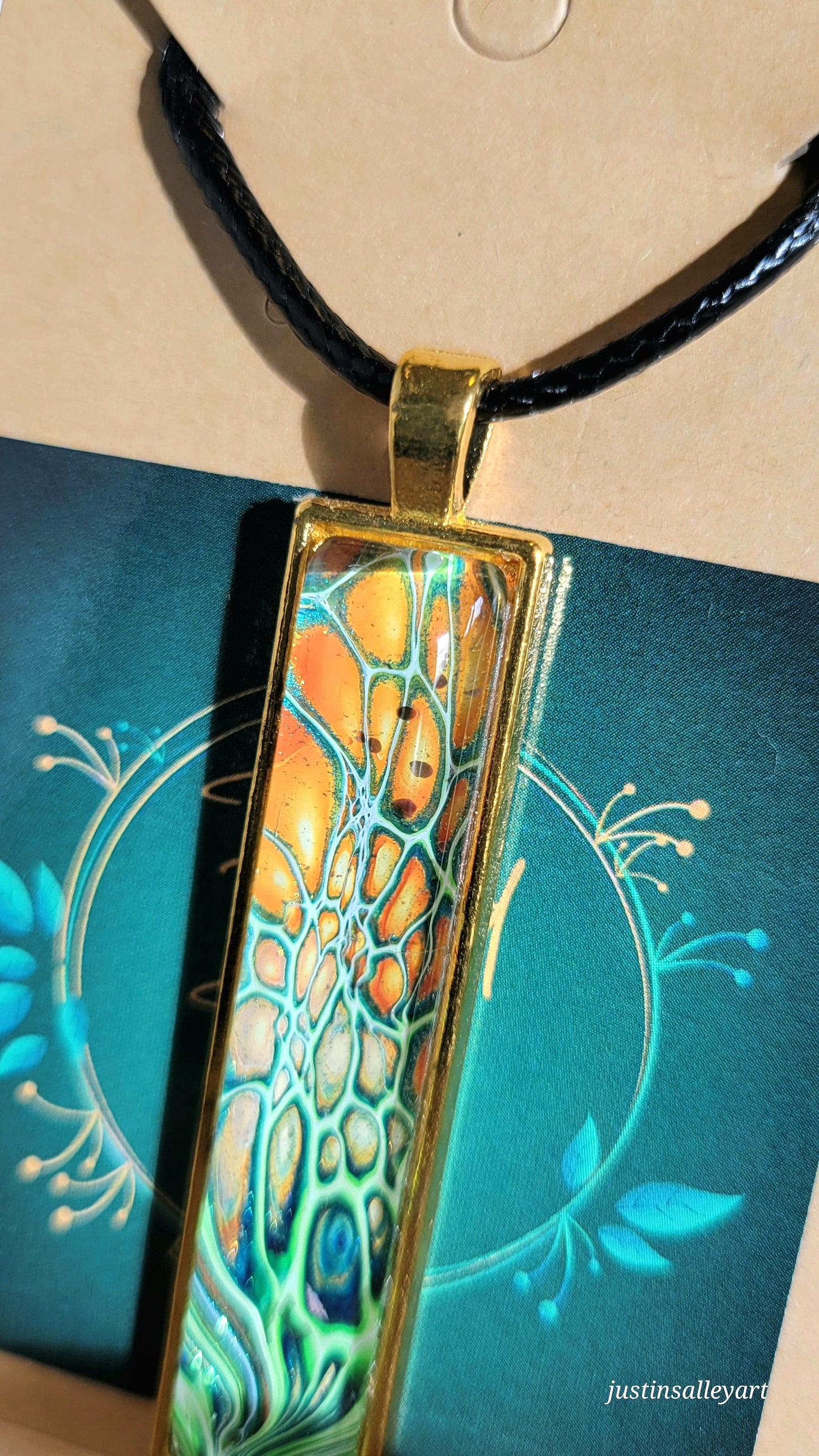Handmade Fluid Art Gold Pendant on a black cord necklace with lobster clasp.